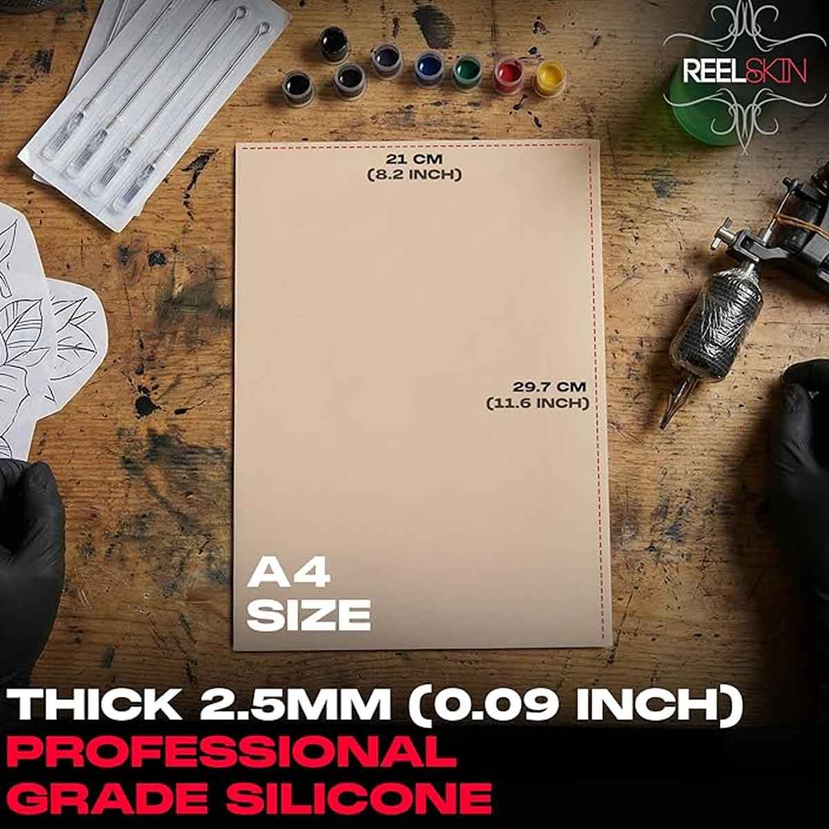 A4 size silicone sheet on a wooden surface with tattoo supplies.