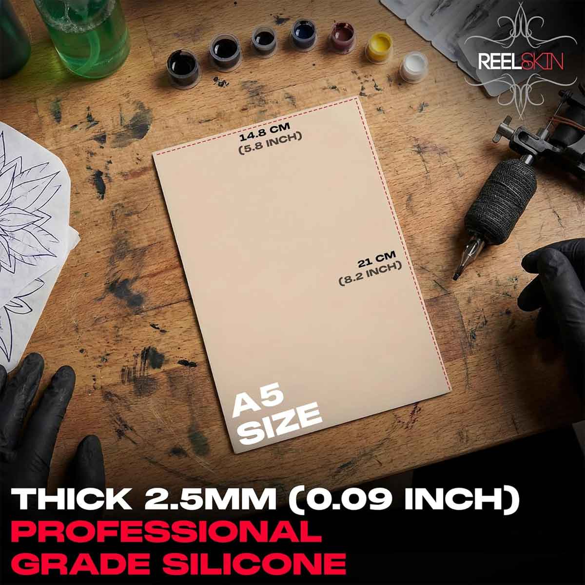 A5 size silicone sheet on a tattoo studio table with tattoo equipment and ink bottles.